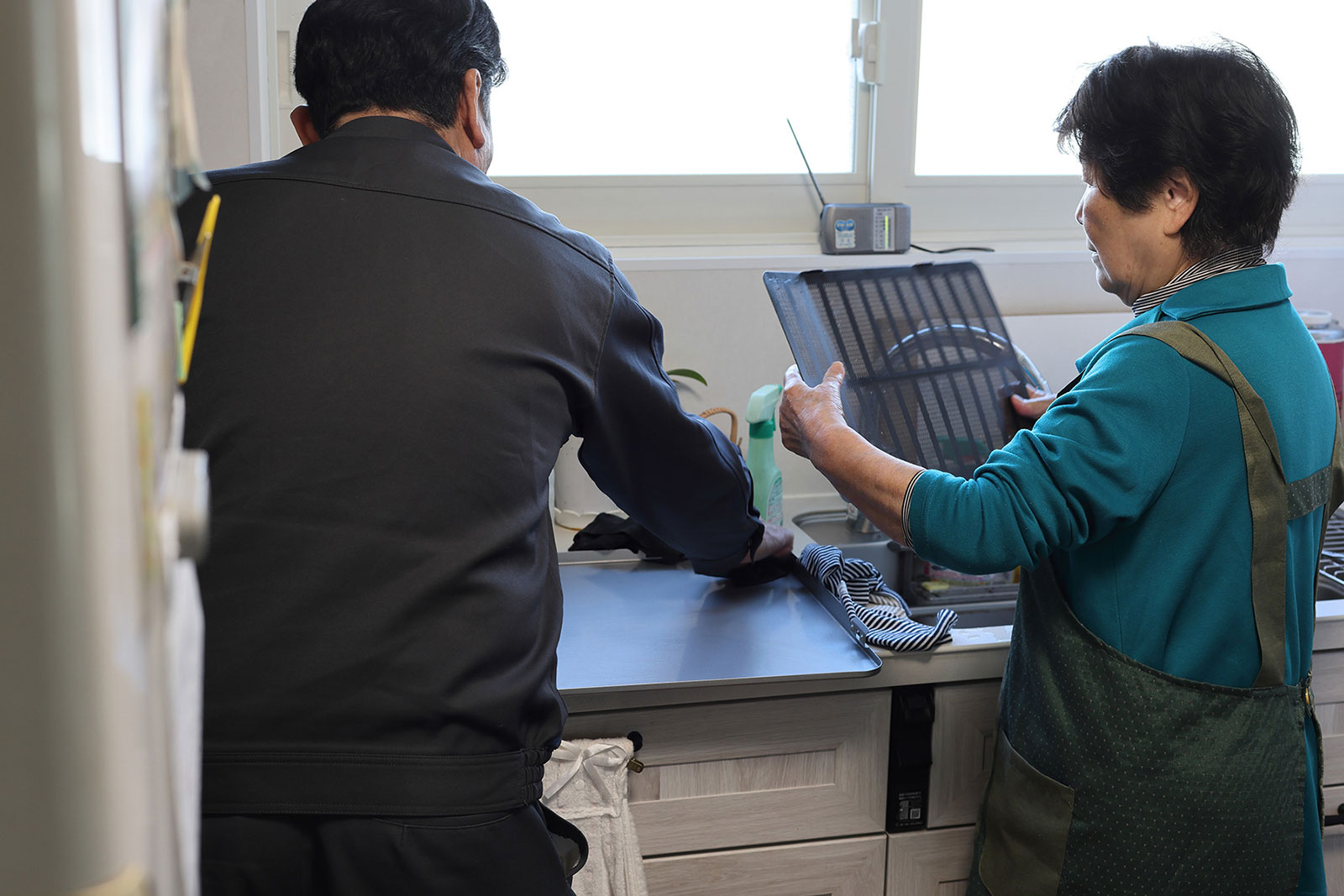 類家と共に換気扇を掃除するH様